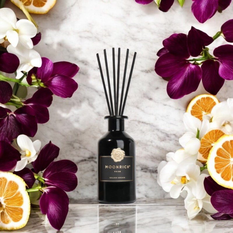 Moonrich Golden Orchid Flakon umgeben von Orchideenblüten und Zitrusscheiben – visuelle Darstellung des eleganten Duftprofils.